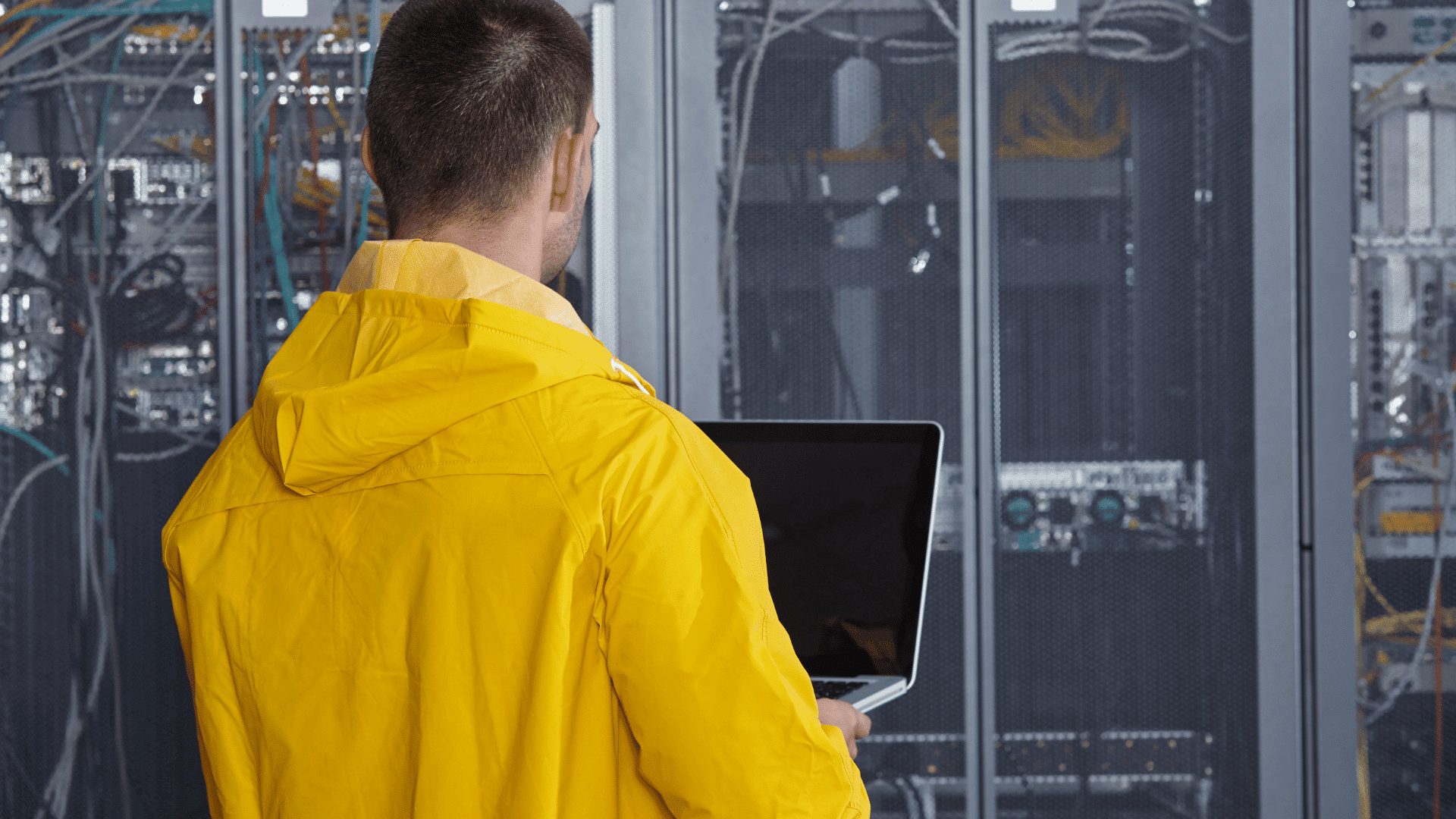 sistemista davanti a un rack che tiene sotto controlla la temperature dei server