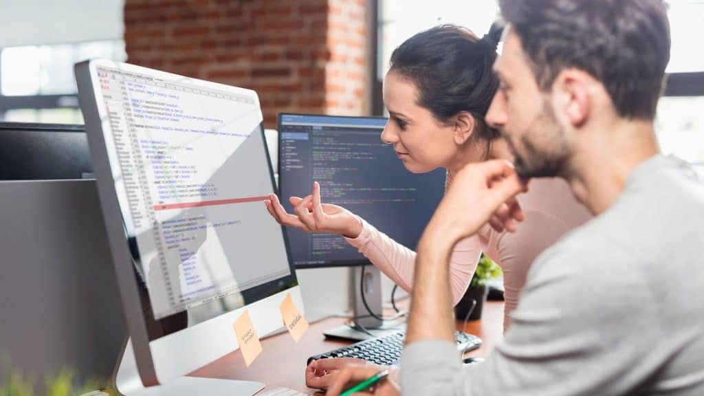 sviluppatori backend che analizzano righe di codice allo schermo di un desktop