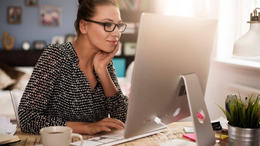 impiegata di un ufficio davanti a un pc che utilizza servizi cloud in un'azienda