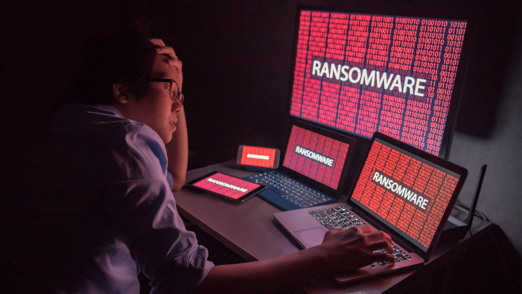 Persona davanti a dispositivi attaccati da ransomware